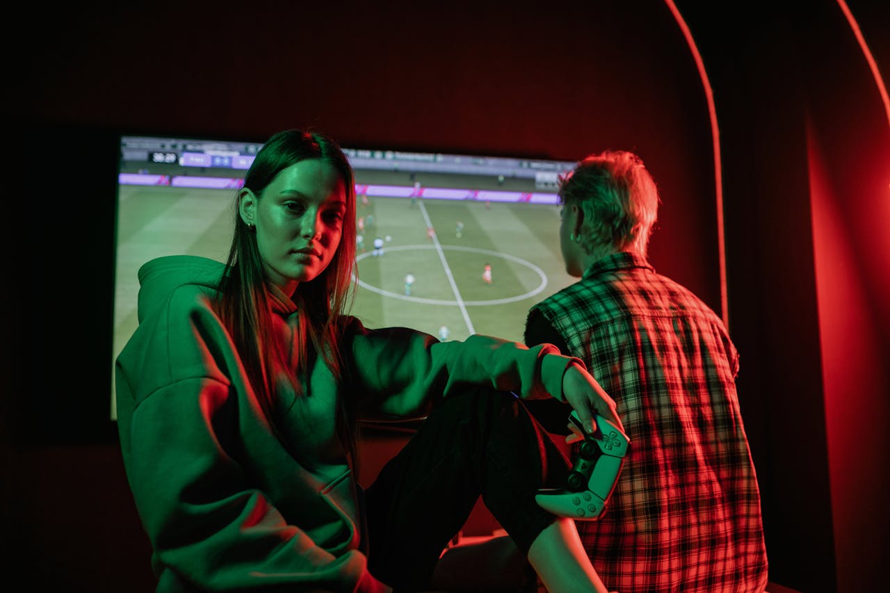 Two young adults playing video games intensely indoors with gaming controllers.